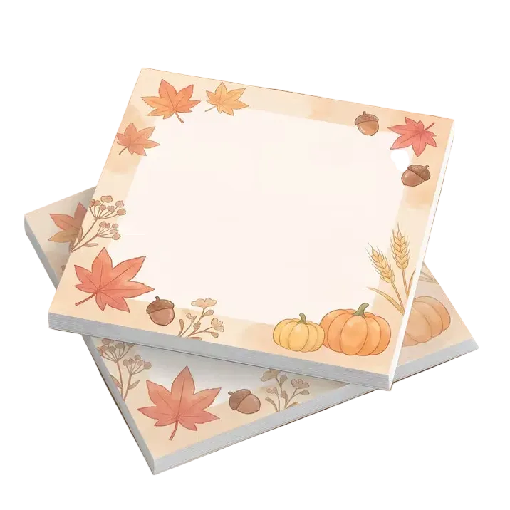 Three square sticky note pads with an autumn-themed border featuring maple leaves, pumpkins, acorns, and wheat, arranged on a wooden tabletop.