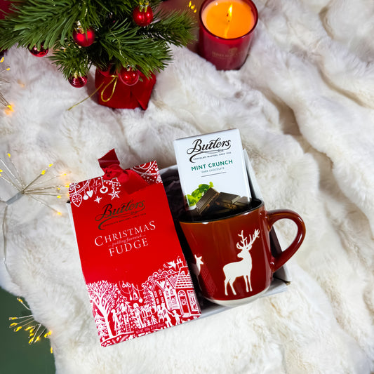 Butlers Christmas fudge, mint crunch chocolate, and a mug with a reindeer design with a festive christmas background