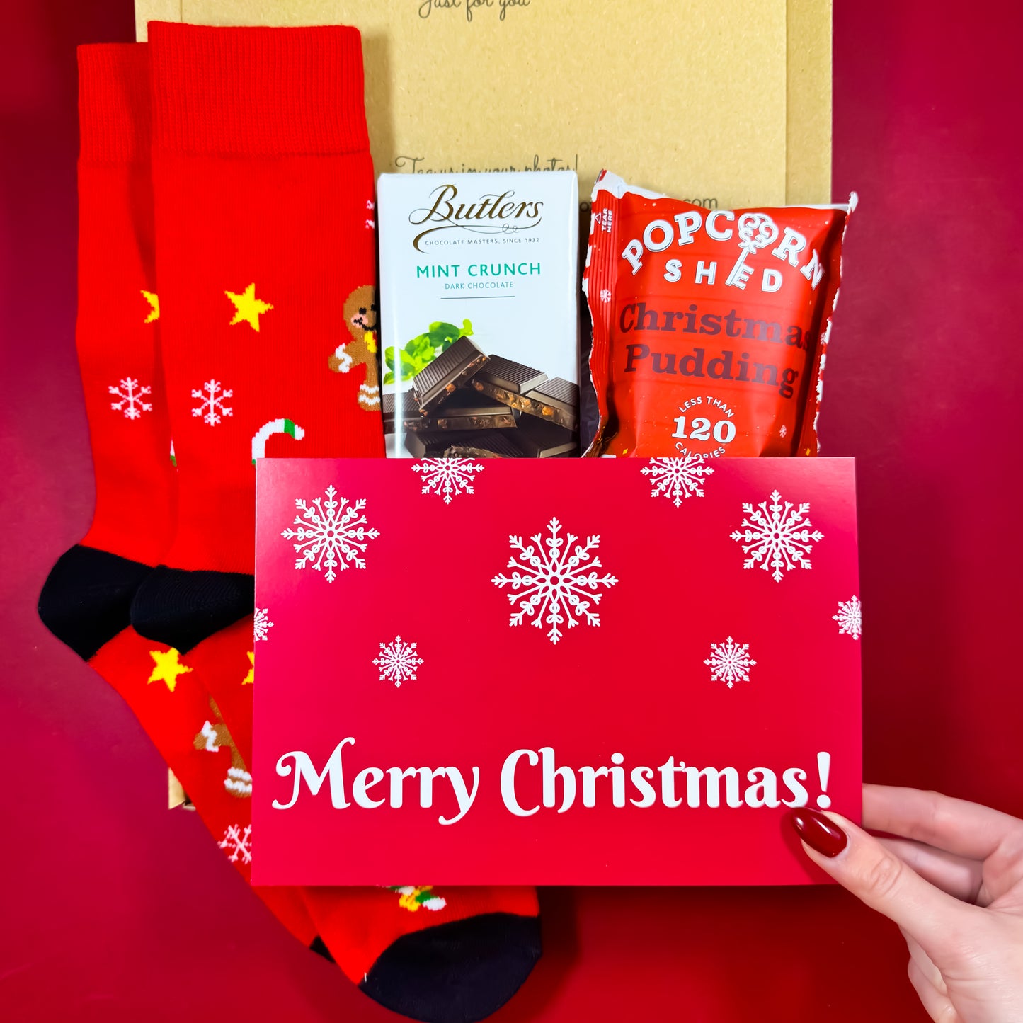 Winter Warmer Christmas Care Box with festive men’s socks, Butlers Mint Crunch chocolate, Christmas Pudding popcorn and a Merry Christmas notecard.