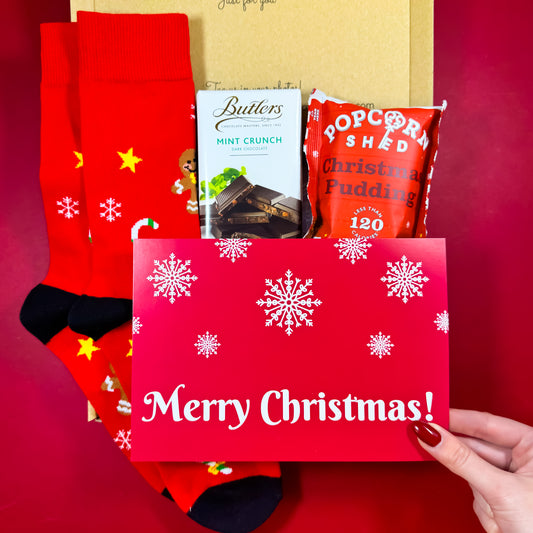 Winter Warmer Christmas Care Box with festive men’s socks, Butlers Mint Crunch chocolate, Christmas Pudding popcorn and a Merry Christmas notecard.