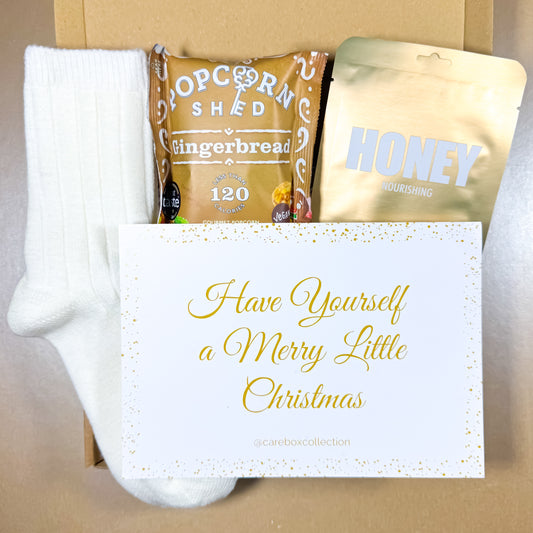 Warm Wishes Christmas Care Box with cosy socks, gingerbread popcorn, honey face mask and a festive “Have Yourself a Merry Little Christmas” card.